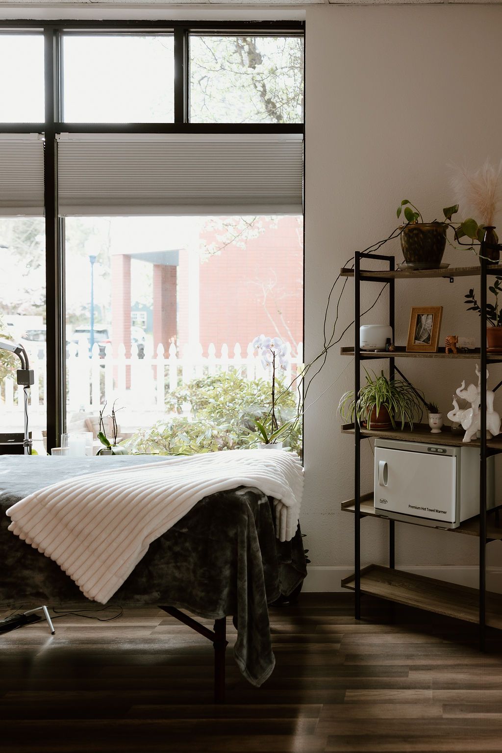 Lash room with a bed, a soft blanket and a window onto the street