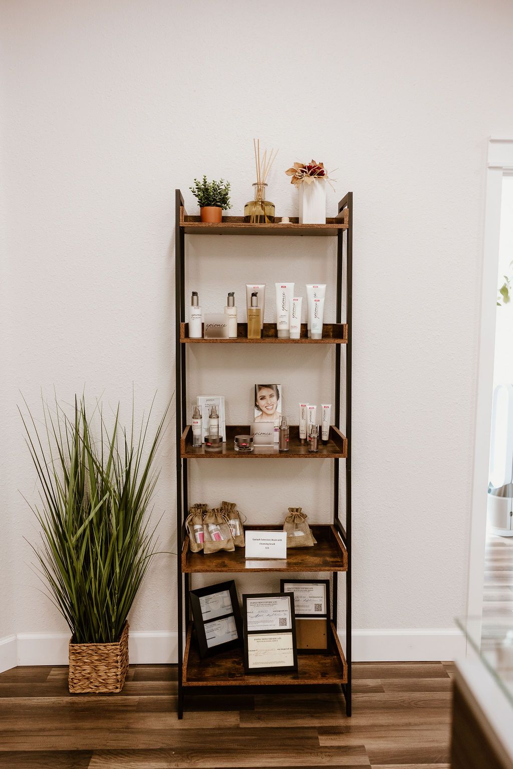 Shelf of skincare products with a plant beside it