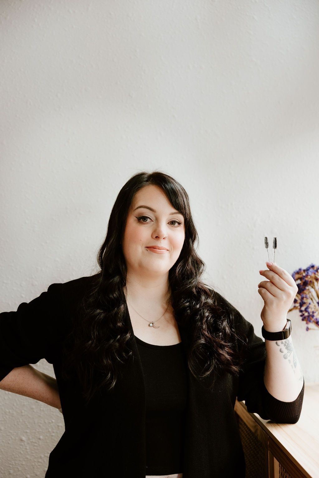 Lash artist holding up two lash wands