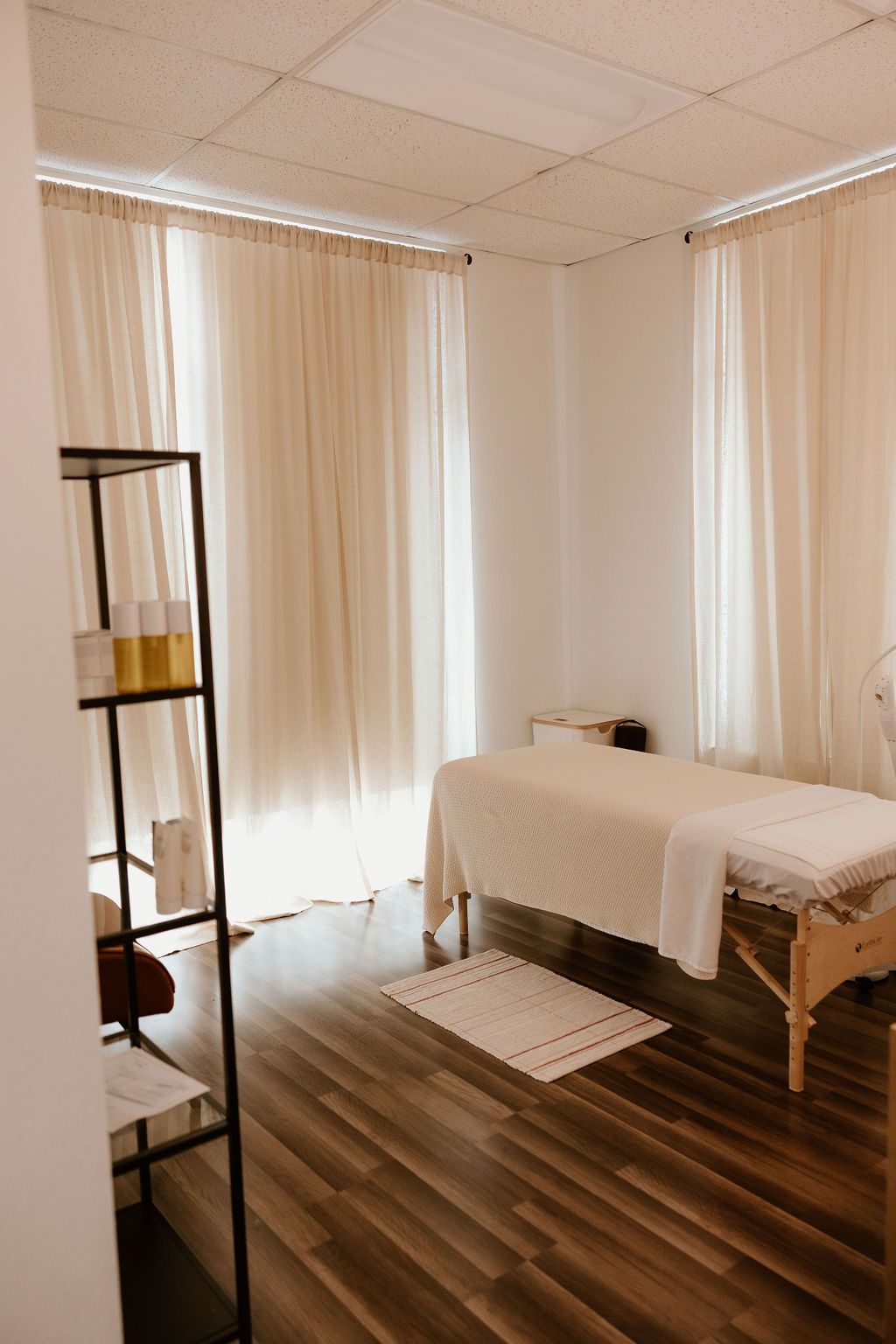 Treatment room with a bed and floor-length curtains
